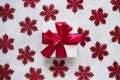 White gift box with red ribbon on a white marble background with red glittering snowflakes. Royalty Free Stock Photo