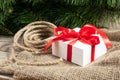 White gift box with red ribbons, cristmas tree branch and rope o Royalty Free Stock Photo