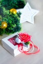 White gift box with red rose and bauble. Greeting card with Christmas tree. New year decoration Royalty Free Stock Photo