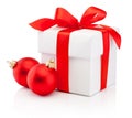 White gift box tied red ribbon bow and two Christmas bauble Isolated on white background Royalty Free Stock Photo