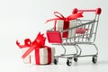 White gift box tied with red ribbon in a shopping cart Royalty Free Stock Photo