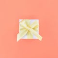 White gift box on coral color background. Square.