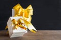 White gift box and yellow ribbon with tag on wood table with spa Royalty Free Stock Photo