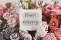 Gift card with the inscription flower delivery in a bouquet of bright beautiful multi-colored roses, the concept of delivery Royalty Free Stock Photo