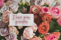 gift card with the inscription I love you grand mother in a bouquet of bright beautiful multi-colored roses Royalty Free Stock Photo