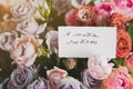 white gift card with the inscription I love you in Russian in a bouquet of bright beautiful multi-colored roses Royalty Free Stock Photo