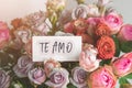 gift card with the inscription i love you on spanish in a bouquet of bright beautiful multi-colored roses, the concept of Royalty Free Stock Photo