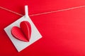 White gift card wih paper hearts on red wooden background. Royalty Free Stock Photo