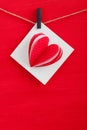 White gift card wih paper hearts on red wooden background. Royalty Free Stock Photo