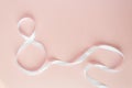 White gift celebration ribbon in 8 digit shape over pink background Royalty Free Stock Photo