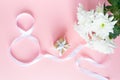 White gift celebration ribbon in 8 digit shape over pink background Royalty Free Stock Photo