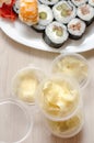 White ginger in plastic disposable jars and rolls. Japanese food delivery home. Vertical photo