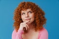 White ginger woman with curly hair thinking and looking upward Royalty Free Stock Photo