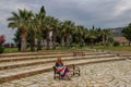 A white girl in a hippie dress sits and rests on a bench in Pamukkale National Park