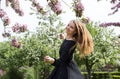 1 white girl with long hair in a black dress spinning in a blooming Apple orchard, girl smiling Royalty Free Stock Photo