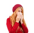 White girl in hat and sweater wiping her nose with a handkerchief on a white isolated background Royalty Free Stock Photo