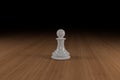 White, glass, chess pawn on a hard wood surface Royalty Free Stock Photo