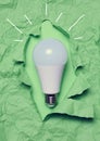 White glass lamp on green crumpled paper, new creative ideas concept