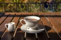 White glass tea cup placed on an old wooden table with green leaves background with soft sunlight in the morning, giving a fresh Royalty Free Stock Photo