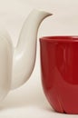 White glazed faience tea pot and red cup