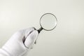 White glove holding magnifier. Royalty Free Stock Photo