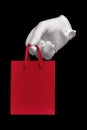 White glove holding red shopping bag