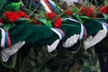 White-gloved hands hold a wreath and flowers in memory of those killed in wars and armed conflicts