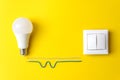 White glowing light bulb and white switch with wires phase, zero, ground. Save energy concept Royalty Free Stock Photo