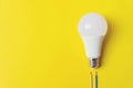 White glowing light bulb with wires phase, zero, ground Royalty Free Stock Photo