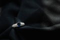 White gold with blue sapphire and diamond ring isolated on black fabric background Royalty Free Stock Photo
