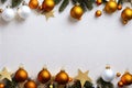 a white and gold christmas background with ornaments and fir branches on a white wall with a gold star and a gold and white baub Royalty Free Stock Photo