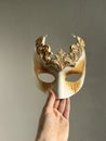 White gold masquerade Venetian mask in hand Royalty Free Stock Photo