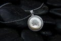 White gold pendant with Nacre and diamonds on black stones background Royalty Free Stock Photo