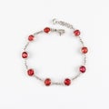 White gold or silver bracelet with red ruby gemstone on light background.