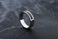 White gold wedding ring with black gemstones on black background Royalty Free Stock Photo