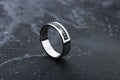 White gold wedding ring with black gemstones on black background Royalty Free Stock Photo