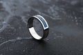 White gold wedding ring with blue gemstones on black background Royalty Free Stock Photo