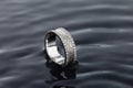 White gold wedding ring with diamonds on black water background Royalty Free Stock Photo