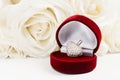 White golden pendant with stones in red gift jewelry box and white roses bouquet