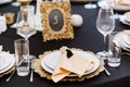 White and golden plates on black tablecloth. Beautiful service of wedding tables. Royalty Free Stock Photo