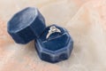 White golden wedding ring with diamonds in blue vintage velvet r Royalty Free Stock Photo