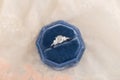 White golden wedding ring with diamonds in blue vintage velvet r Royalty Free Stock Photo