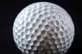 White golf ball on a dark background highlighting the texture of the dimples Royalty Free Stock Photo