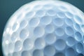 White golf ball with dimples reflecting light on textured surface, creating abstract pattern Royalty Free Stock Photo