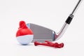 White golf ball with funny cap and golf club on the white background. Royalty Free Stock Photo