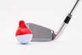 White golf ball with funny cap and golf club on the white background. Royalty Free Stock Photo