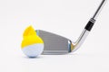 White golf ball with funny cap and golf club on the white background. Royalty Free Stock Photo