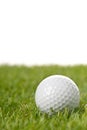 White golf ball on green grass lawn with copy space, isolated on white background Royalty Free Stock Photo