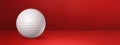 White golf ball on a red studio banner Royalty Free Stock Photo