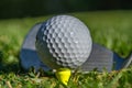 White golf ball teed up on a yellow tee Royalty Free Stock Photo